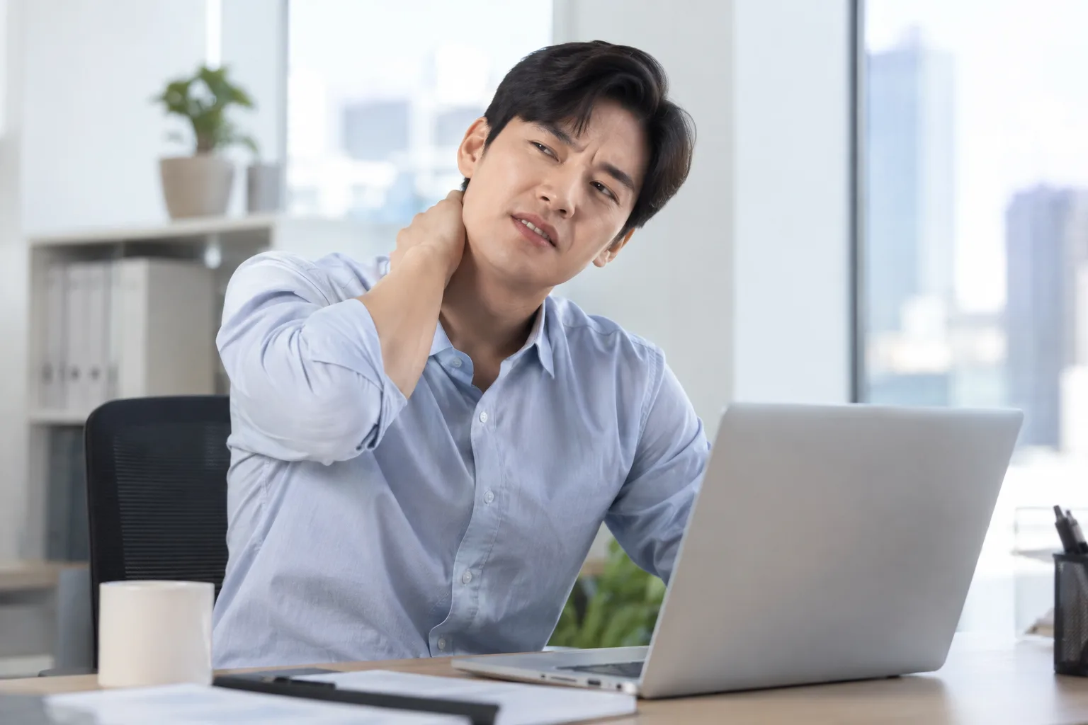오래 앉아 목과 허리에 부담을 느끼는 모습